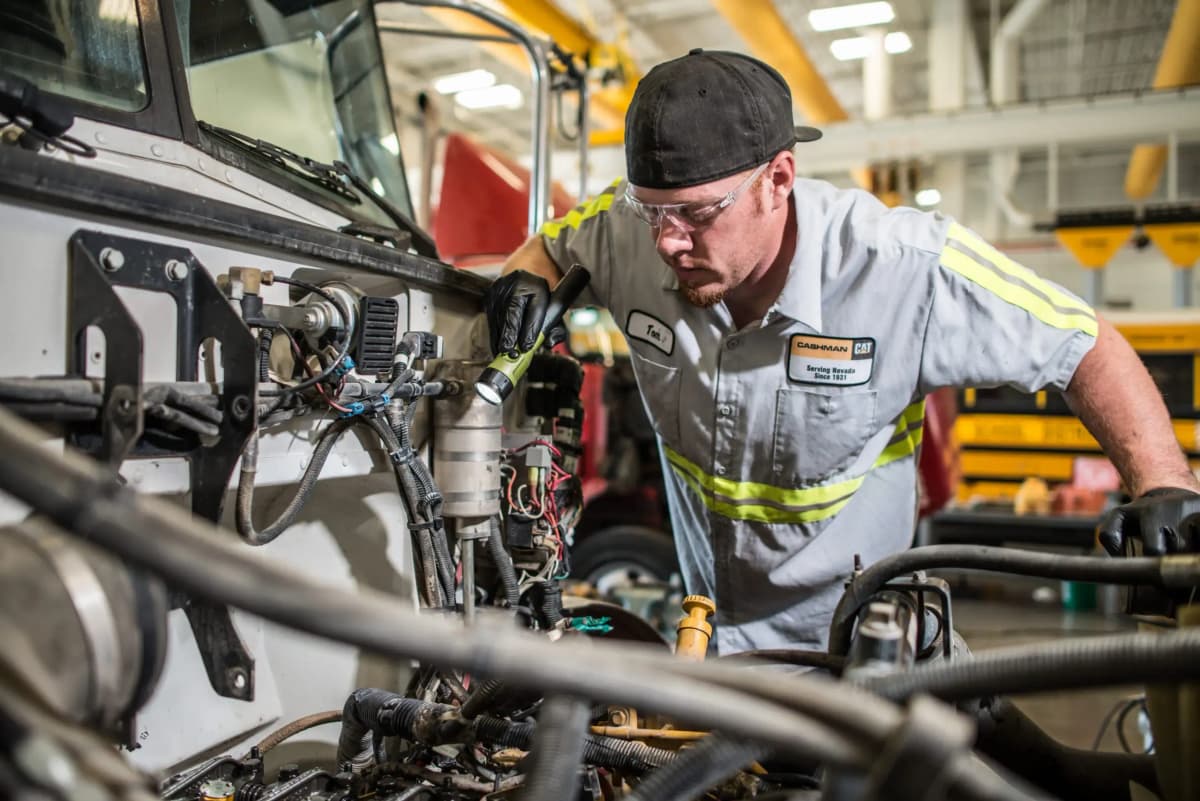 Técnico revisando motor de camión en taller especializado