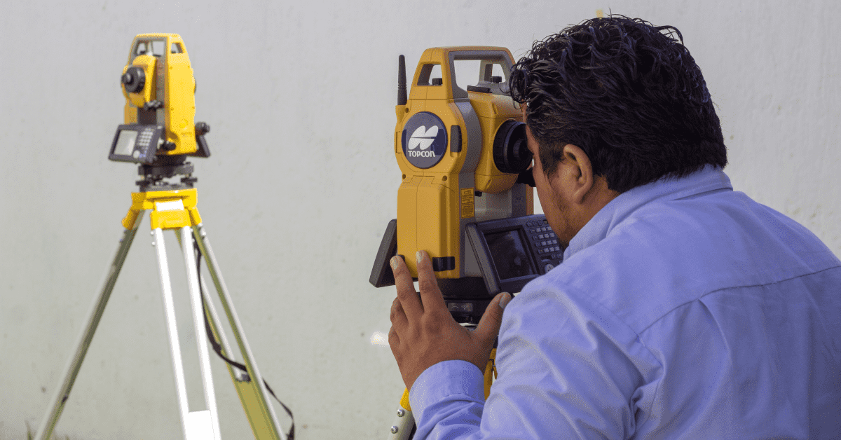 Ingeniero usando estación total topográfica en obra