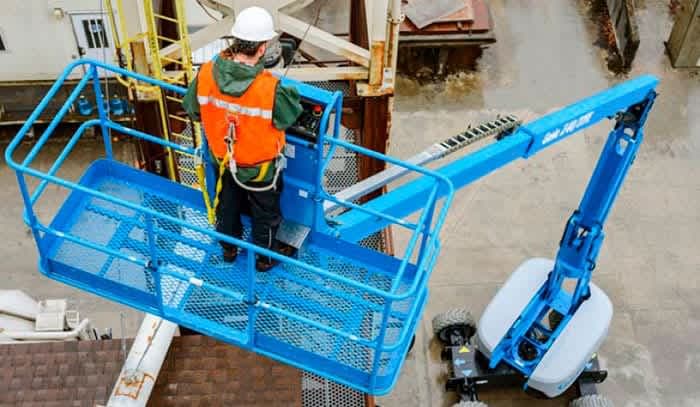 Operarios usando arneses de seguridad en manlift