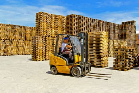 Montacargas en pleno movimiento elevando pallets